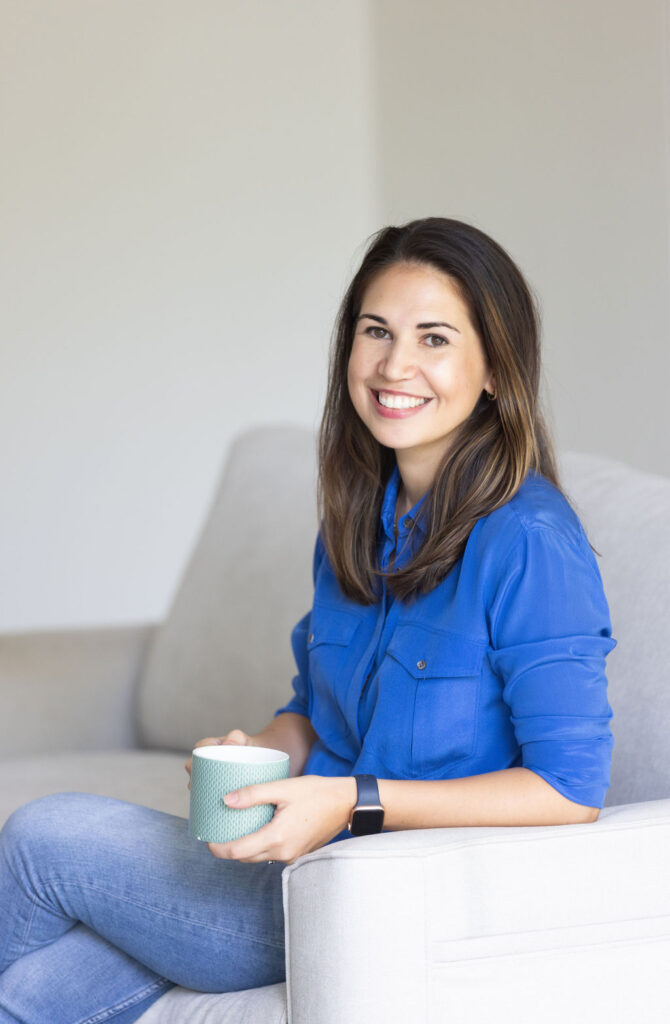 Elena Kersey smiling towards the camera with cup of tea