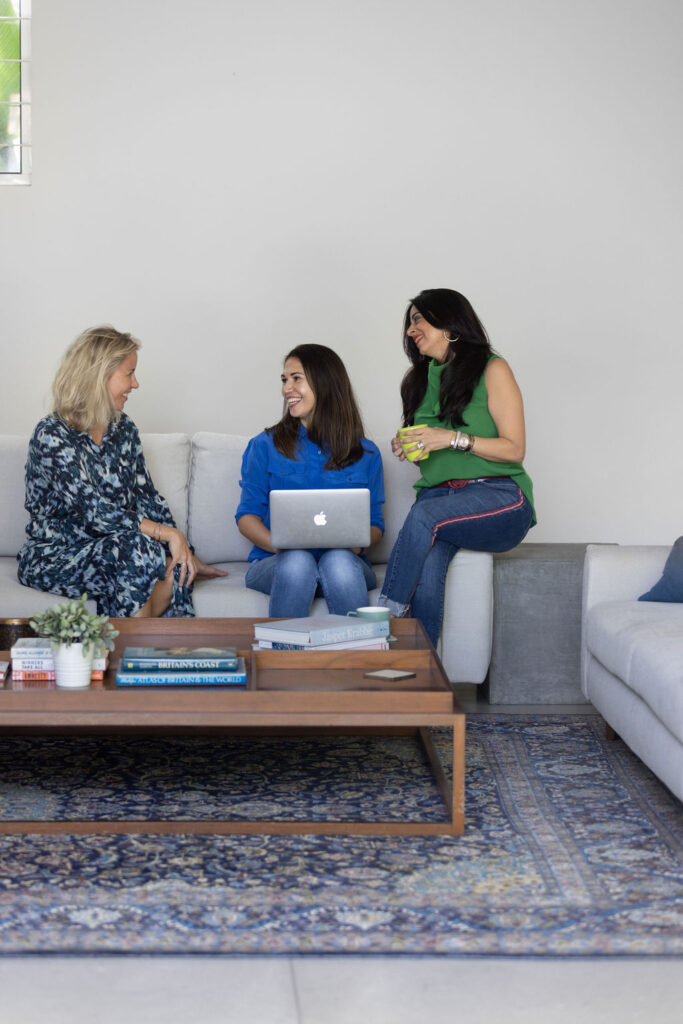 Three woman, including Elena Kersey, sat comfortably on sofa working on laptop.